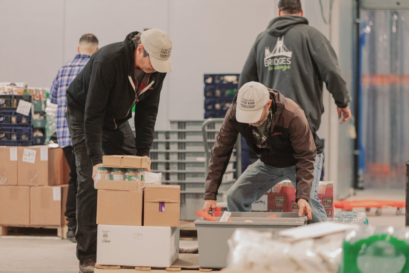 Staff and volunteers organize boxes of food at a warehouse, preparing shipments for Oregon communities in response to the SNAP disruption.